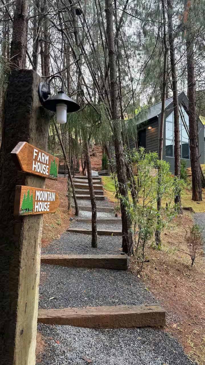 A placa indicando Farm House e Mountain House na trilha de escadas de dormentes